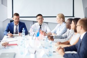 Several delegates sitting by table at summit or forum